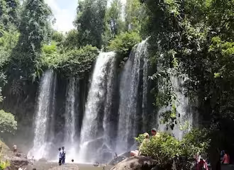 Scenic view of the sacred Phnom Kulen waterfall surrounded by tropical forest in Kulen Mountain National Park, Cambodia.
